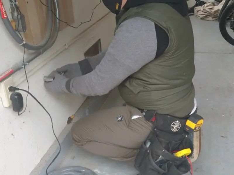 Electrician performing outlet wiring in a O'Fallon garage